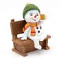 Preview: Ein lustiger Polyresin-Schneemann "Feierabend" auf einer Bank, grün/rot orange/grau.
