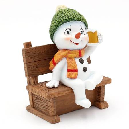 Ein lustiger Polyresin-Schneemann "Feierabend" auf einer Bank, grün/rot orange/grau.