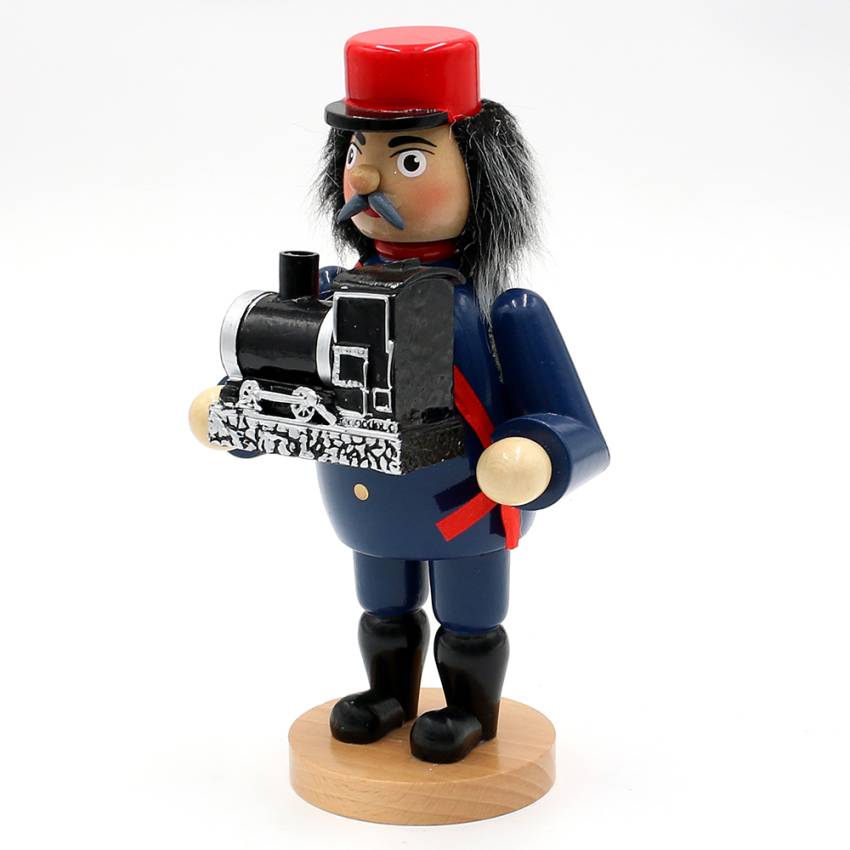 Räuchermann im Eisenbahner‑Outfit mit roter Mütze und blauer Uniform, der eine schwarze Dampflok präsentiert; klassische erzgebirgische Handwerkskunst.