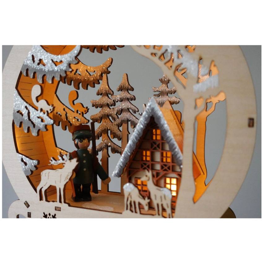 „Detailansicht: Holz-Diorama mit Winterwald, beleuchtetem Jagdhaus und filigranen Tiersilhouetten“ timerfunktion