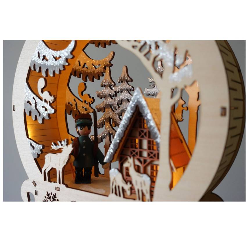 „Detailansicht: Holz-Diorama mit Winterwald, beleuchtetem Jagdhaus und filigranen Tiersilhouetten“ timer